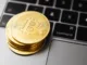 stacks gold round coins on laptop