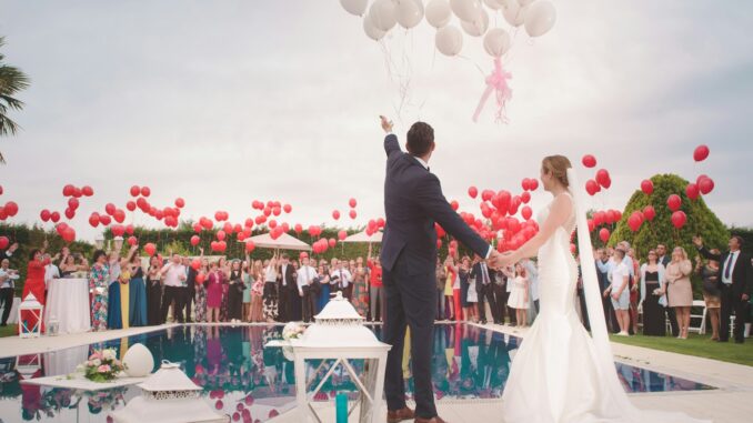 photo of a man and woman newly wedding holding a balloons