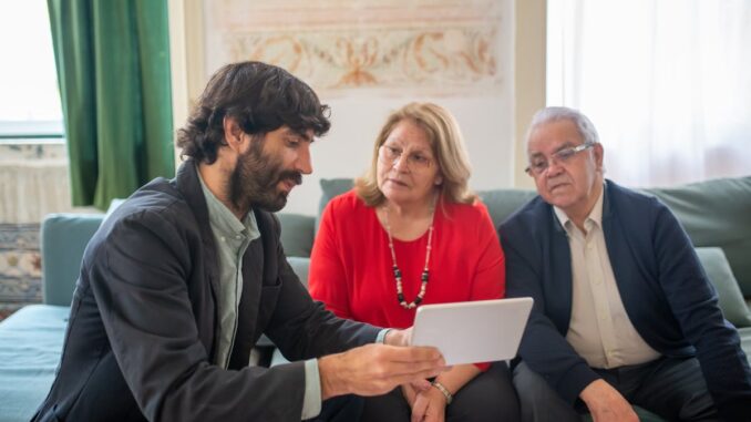 Broker Presenting an Offer to an Elderly Couple on a Tablet