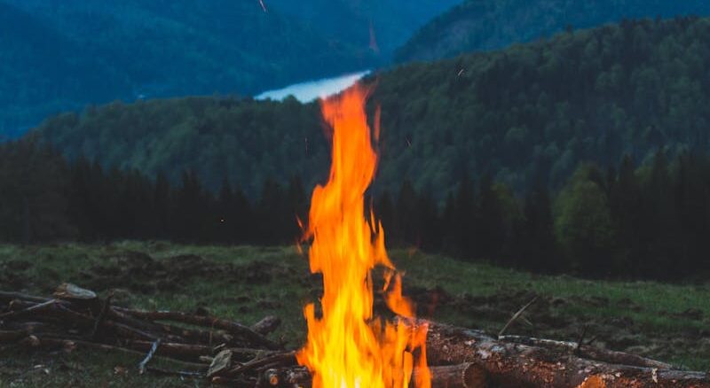 Bonfire Near Grass Field during Dawn